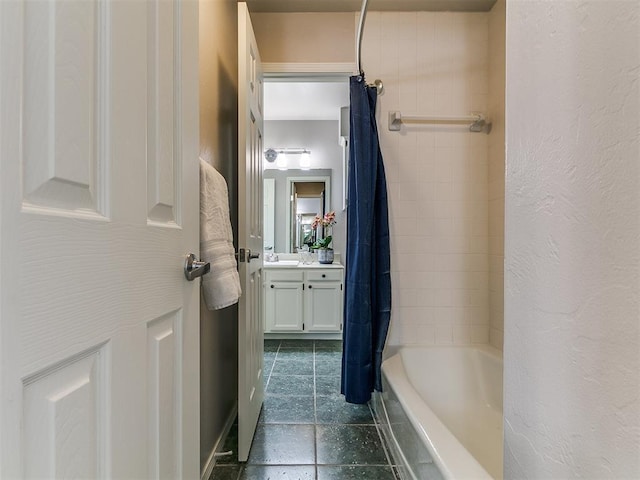 bathroom with tile patterned floors, shower / bath combo with shower curtain, vanity, and a textured wall