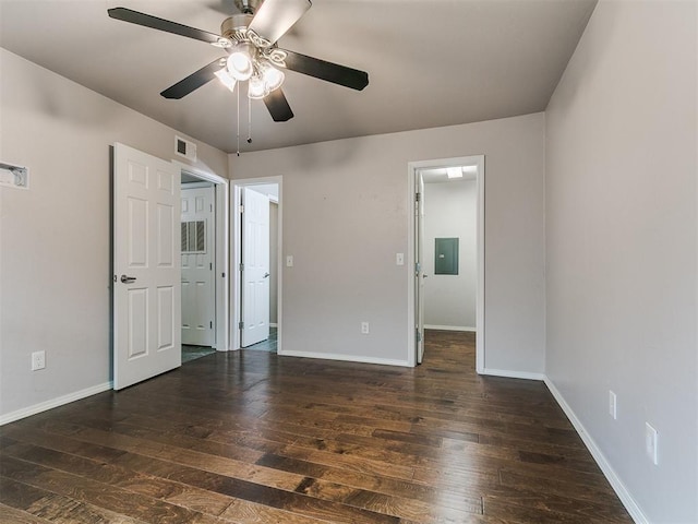 unfurnished bedroom featuring electric panel, baseboards, and hardwood / wood-style floors