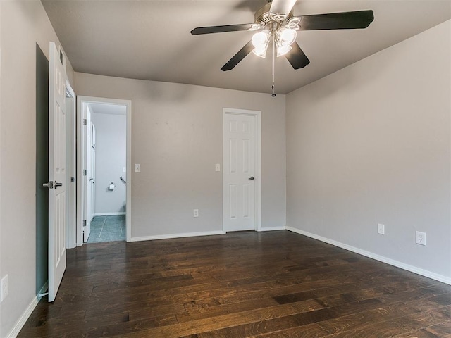spare room featuring dark wood-type flooring, baseboards, and a ceiling fan
