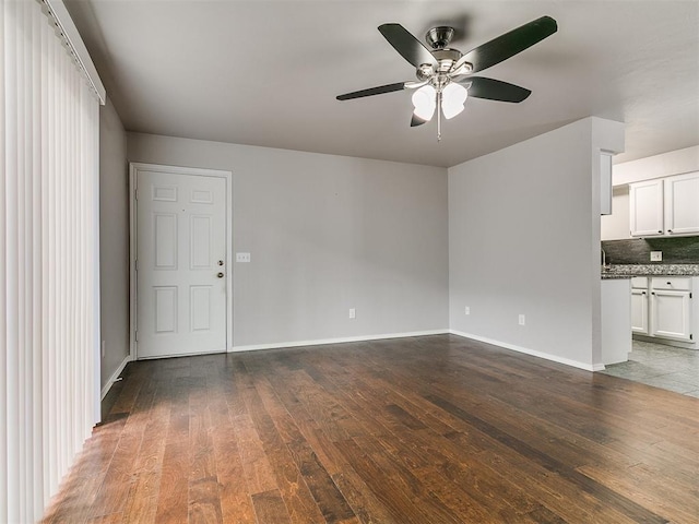 unfurnished room featuring ceiling fan, baseboards, and hardwood / wood-style floors