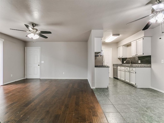 kitchen featuring dishwasher, baseboards, ceiling fan, open floor plan, and dark countertops
