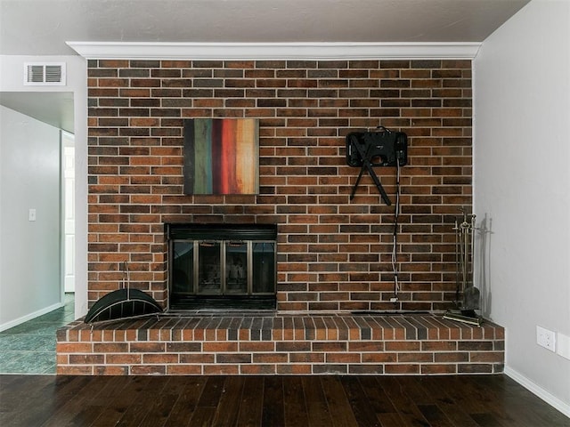 room details featuring a fireplace, baseboards, visible vents, and wood finished floors