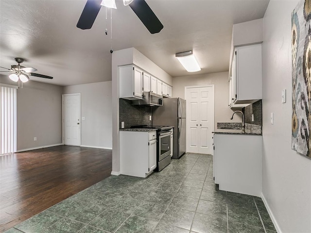 kitchen featuring appliances with stainless steel finishes, tasteful backsplash, a ceiling fan, and a sink