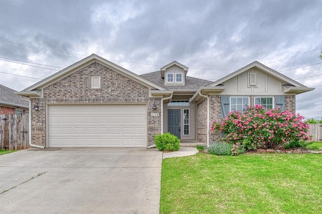 1114 Old Frisco Rd, Norman, OK 73069 - view of front facade with concrete driveway, brick siding, fence, and a front lawn