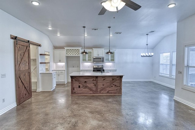 1114 Old Frisco Rd, Norman, OK 73069 - kitchen with appliances with stainless steel finishes, tasteful backsplash, vaulted ceiling, a barn door, and concrete floors