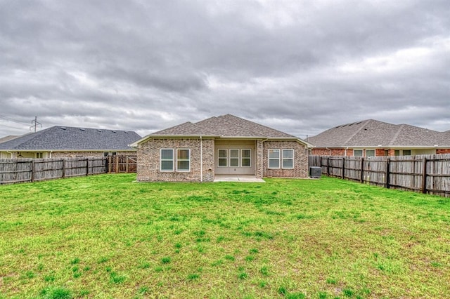 1114 Old Frisco Rd, Norman, OK 73069 - back of property featuring a lawn, a patio area, brick siding, central AC, and a fenced backyard