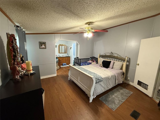 bedroom with crown molding, a textured ceiling, ceiling fan, and wood finished floors