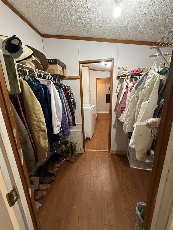 spacious closet with independent washer and dryer and wood finished floors