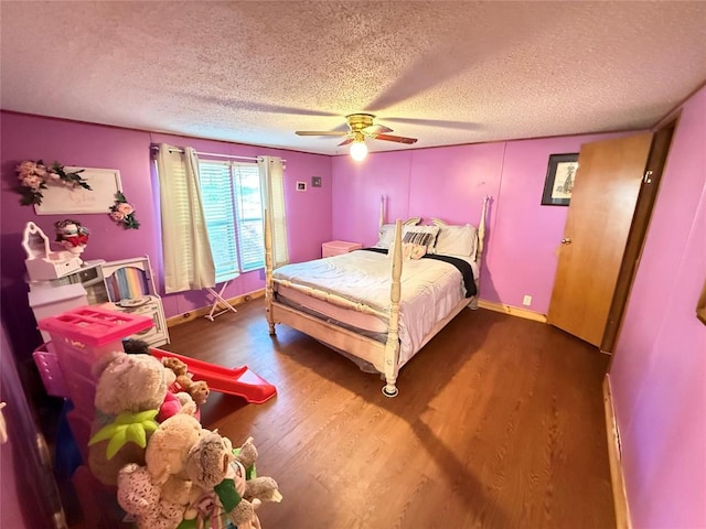 bedroom with a textured ceiling, ceiling fan, baseboards, and wood finished floors