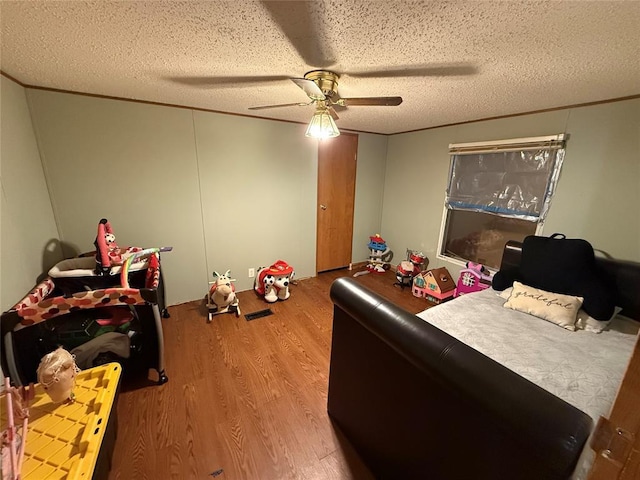 bedroom with a ceiling fan, a textured ceiling, and wood finished floors