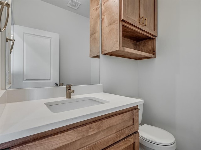 half bathroom with toilet, visible vents, and vanity