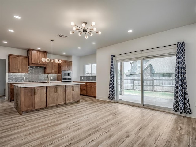 kitchen featuring light countertops, appliances with stainless steel finishes, light wood finished floors, and visible vents