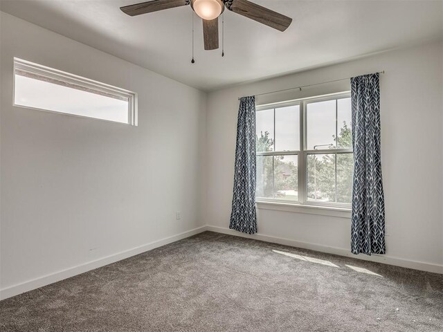 unfurnished room featuring a ceiling fan, baseboards, a wealth of natural light, and carpet
