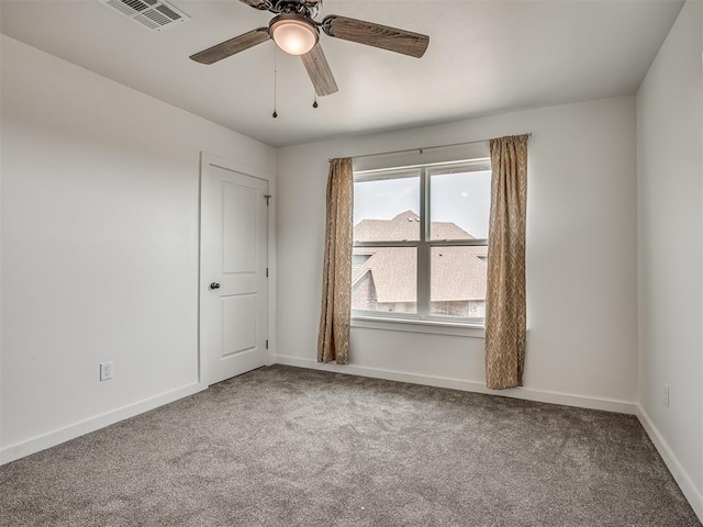 empty room with baseboards, ceiling fan, carpet, and visible vents