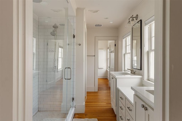 201 NW 18th St, Oklahoma City, OK 73103 - full bathroom with crown molding, vanity, a shower stall, wood finished floors, and visible vents