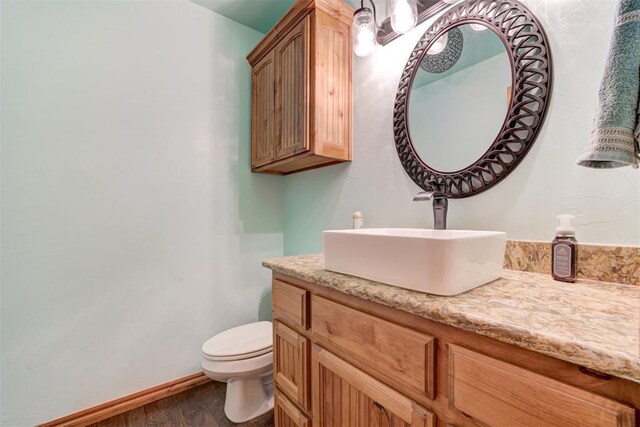 10608 Oaksplinter Ln, Oklahoma City, OK 73173 - bathroom featuring vanity, baseboards, toilet, and wood finished floors