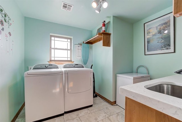 10608 Oaksplinter Ln, Oklahoma City, OK 73173 - clothes washing area featuring visible vents, a sink, baseboards, light tile patterned flooring, and washer and clothes dryer