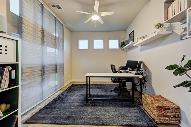 office with baseboards, a ceiling fan, wood finished floors, and visible vents