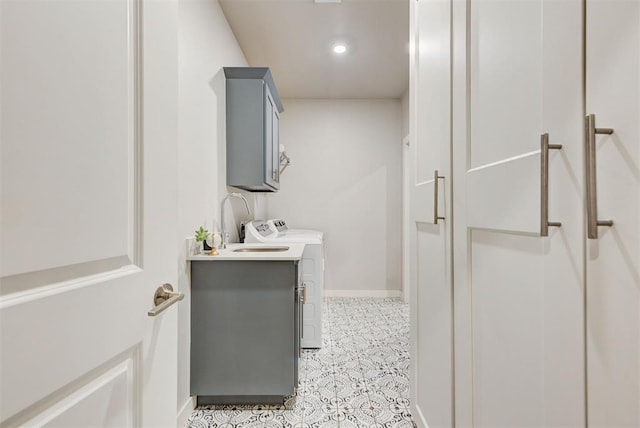 clothes washing area with baseboards, washing machine and dryer, recessed lighting, and cabinet space