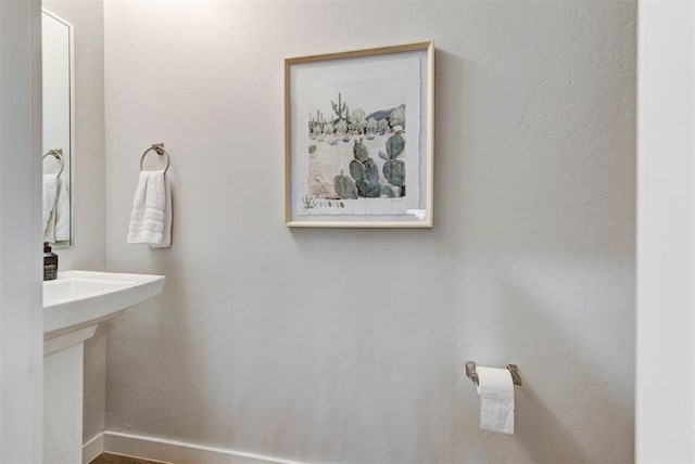 bathroom with baseboards and a sink