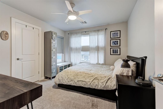 bedroom featuring ceiling fan, visible vents, light carpet, and baseboards