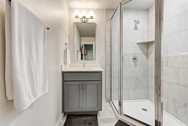 bathroom featuring vanity, a shower stall, and marble finish floor