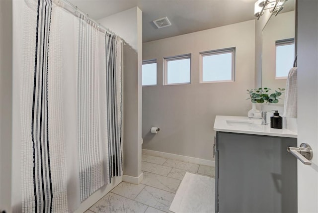 bathroom featuring visible vents, vanity, baseboards, toilet, and marble finish floor