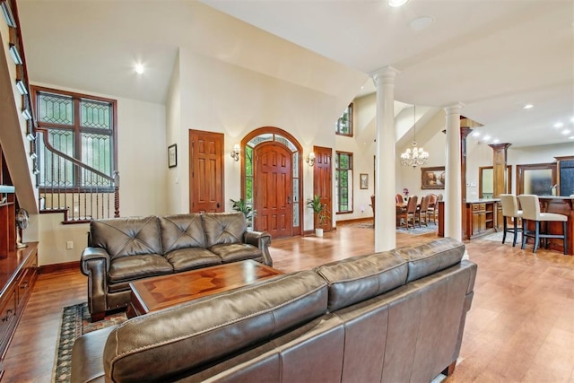living area with stairs, recessed lighting, ornate columns, and wood finished floors