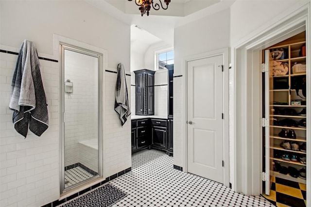 full bathroom featuring a walk in closet and a stall shower