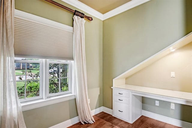 interior space featuring dark wood-type flooring, ornamental molding, baseboards, and built in study area