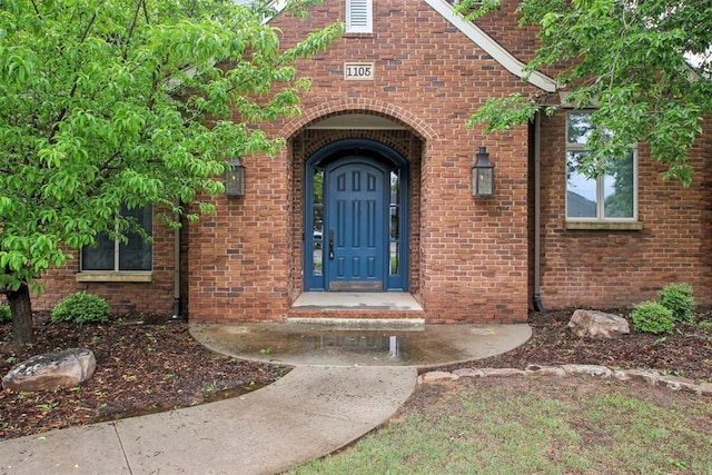view of exterior entry with brick siding