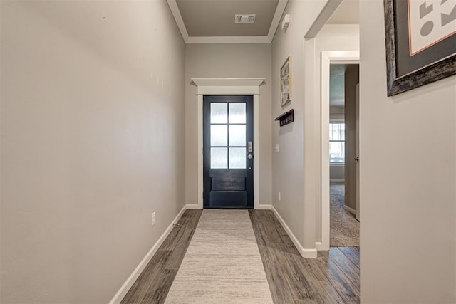 doorway with baseboards, visible vents, ornamental molding, and wood finished floors