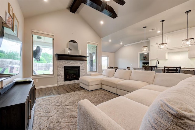 living room with visible vents, lofted ceiling with beams, ceiling fan, and wood finished floors