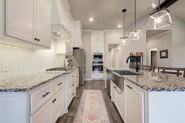 kitchen with a large island, premium range hood, dark wood-type flooring, a sink, and appliances with stainless steel finishes