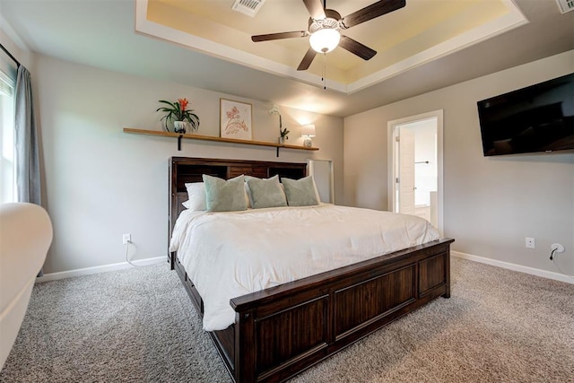 bedroom featuring visible vents, a raised ceiling, and light carpet