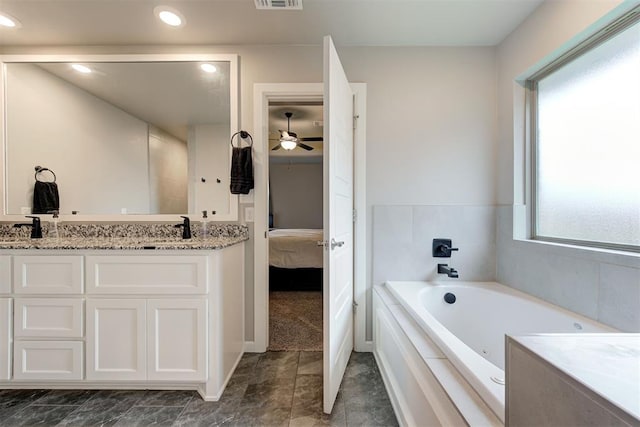 ensuite bathroom featuring visible vents, double vanity, ceiling fan, a whirlpool tub, and ensuite bath