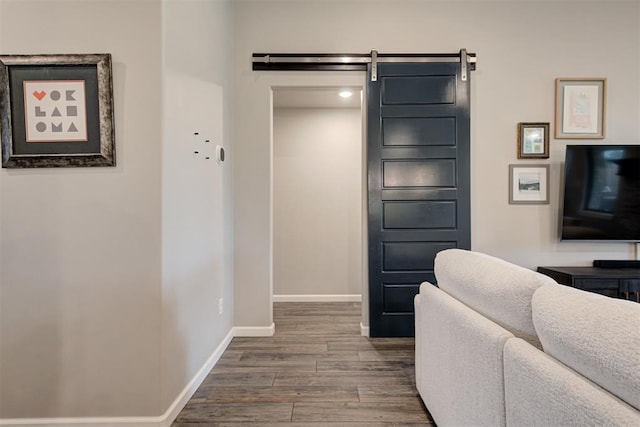 interior space featuring baseboards, dark wood finished floors, and a barn door