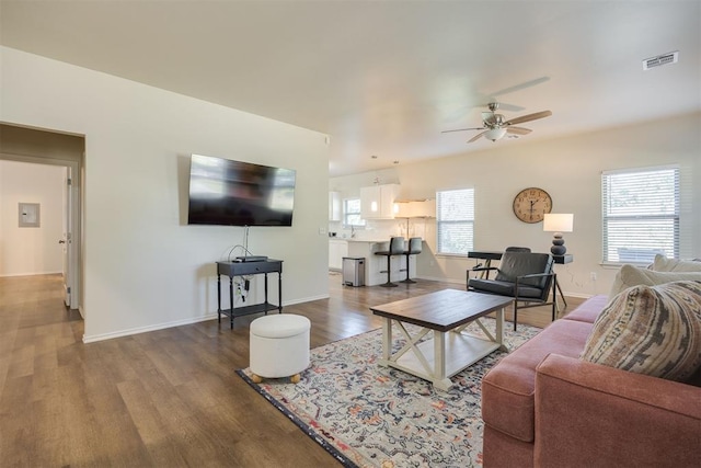 living room featuring baseboards, ceiling fan, wood finished floors, and visible vents