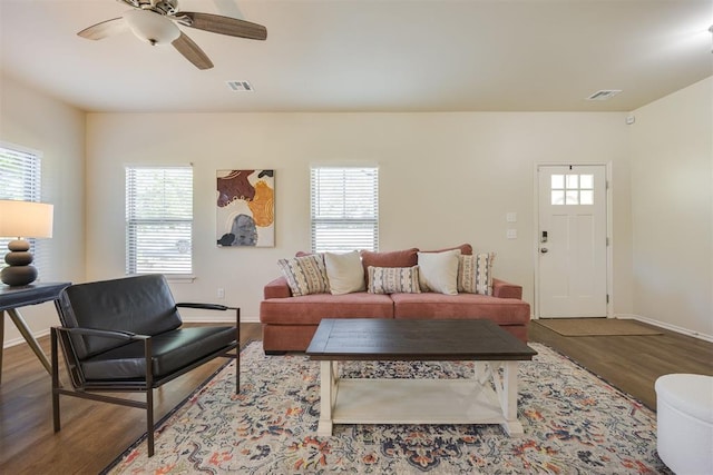 living room with visible vents, baseboards, ceiling fan, and wood finished floors