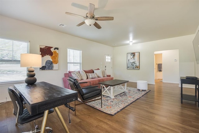 living area featuring baseboards, ceiling fan, wood finished floors, and visible vents
