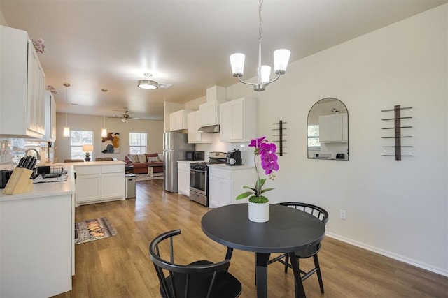dining space featuring baseboards, a notable chandelier, and light wood finished floors