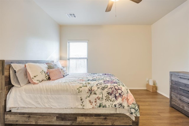 bedroom featuring visible vents, light wood-style floors, ceiling fan, and baseboards