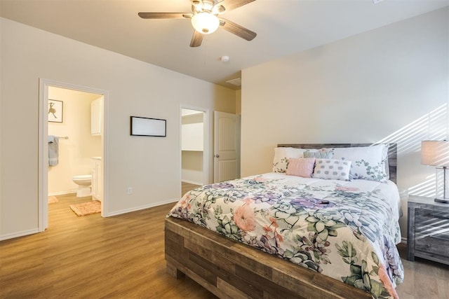 bedroom with baseboards, ensuite bathroom, a ceiling fan, and light wood-style flooring
