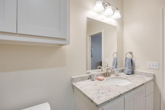 half bathroom featuring vanity and toilet