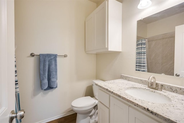 bathroom featuring toilet, a shower with curtain, baseboards, and vanity