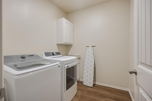 laundry room with cabinet space, baseboards, washing machine and dryer, and wood finished floors