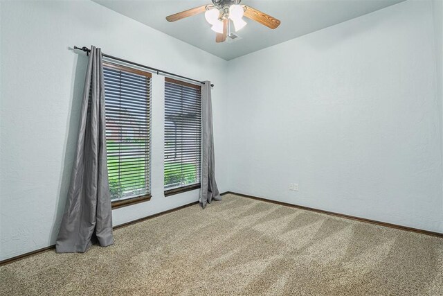 empty room featuring carpet flooring, a ceiling fan, and baseboards