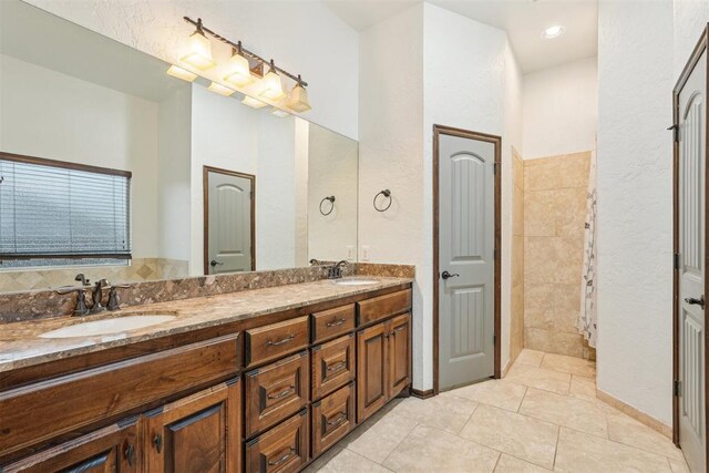 full bath featuring a sink, tile patterned floors, recessed lighting, and double vanity