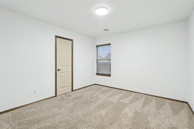 carpeted spare room with baseboards and visible vents