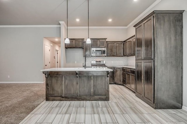 kitchen with a kitchen island with sink, dark brown cabinetry, crown molding, tasteful backsplash, and stainless steel appliances